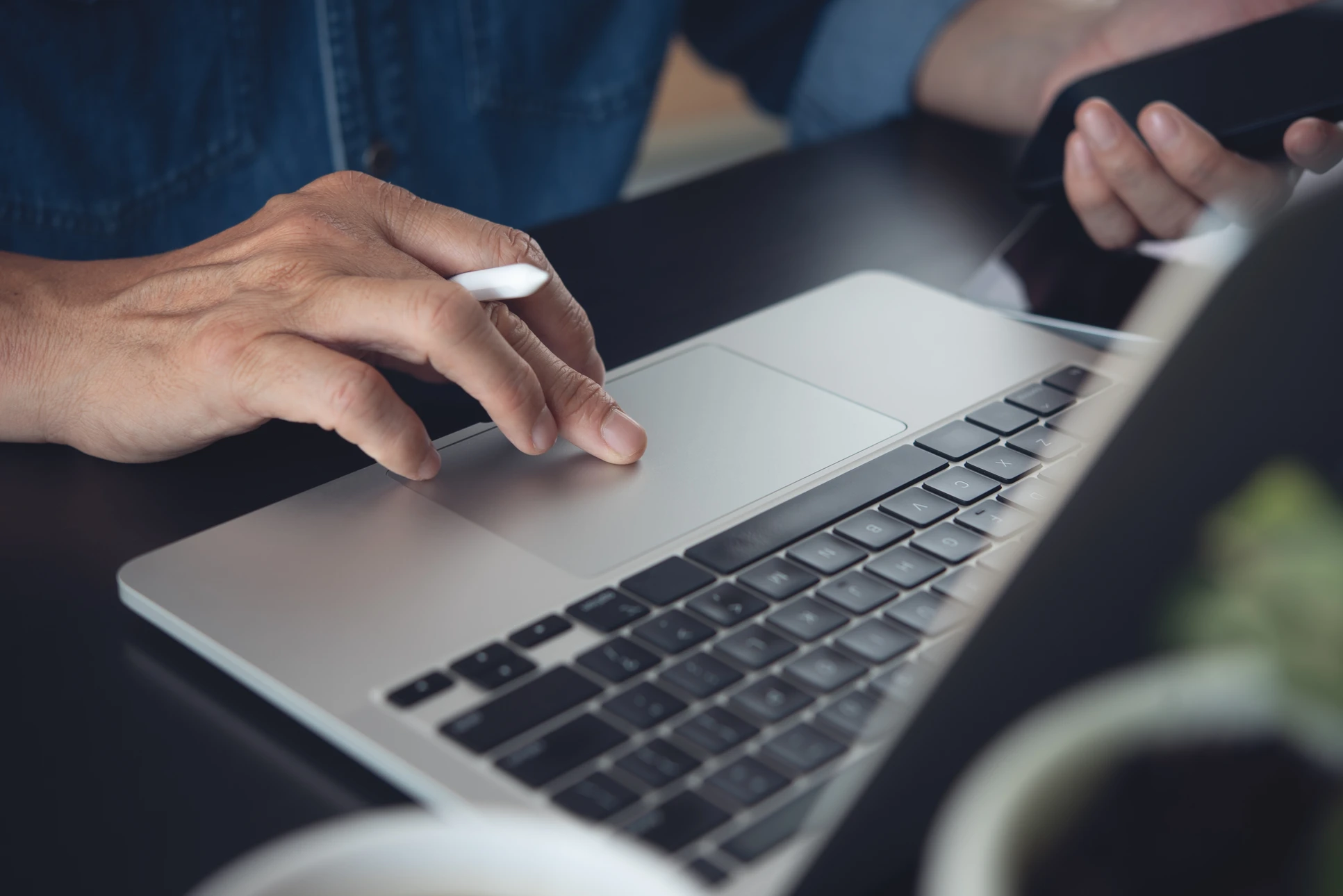Homme d'affaires en costume utilisant une tablette tactile dans un environnement professionnel moderne