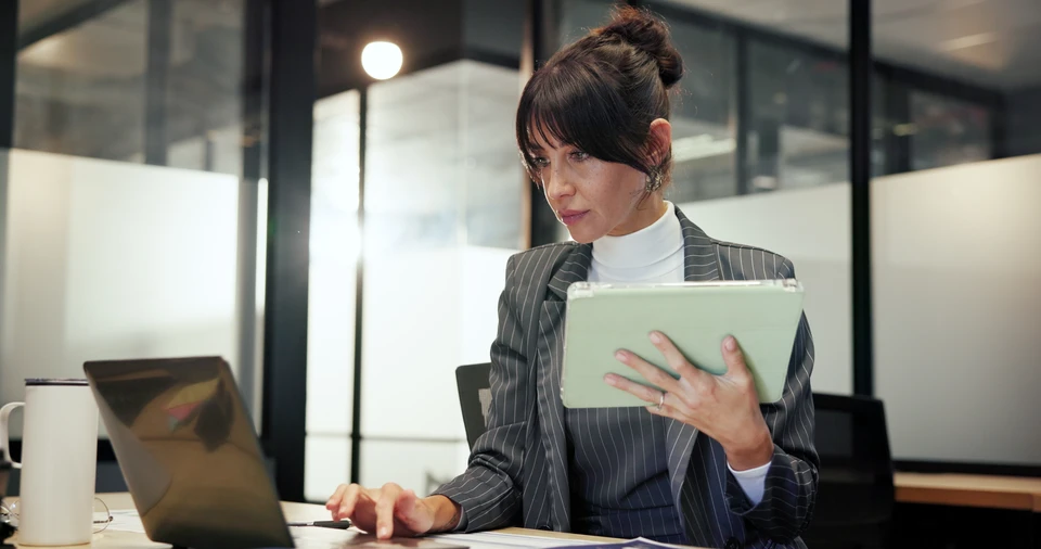 Deux professionnels en tenue d'affaires analysent des données financières dans un bureau moderne