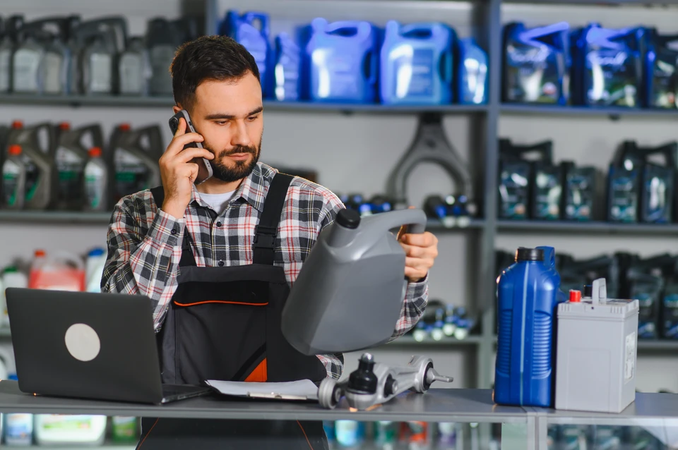 Un entrepreneur ou manager d'une petite entreprise de transport, BTP ou garage, assis à un bureau, travaillant sur un ordinateur de bureau affichant une interface de logiciel de facturation avec des données métier (bons de commande, devis, factures). L'environnement doit refléter le contexte professionnel de ces secteurs d'activité (outils, matériel ou documents visibles en arrière-plan étant caractéristiques du secteur). L'image doit être une photographie réaliste professionnelle.